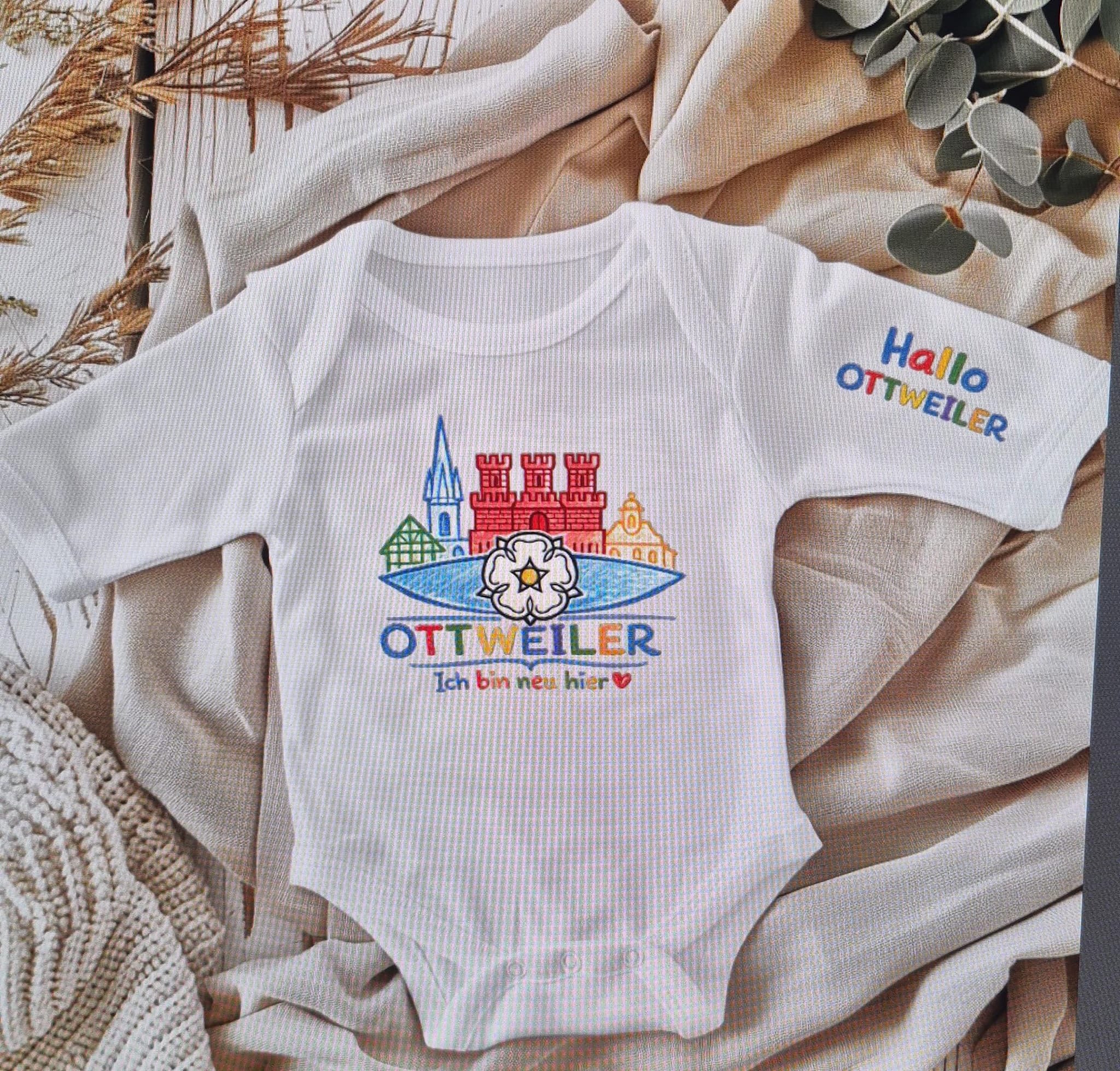 Weißer Ottweiler Baby-Body mit farbigem Stadtmotiv und Schriftzug „Ich bin neu hier“