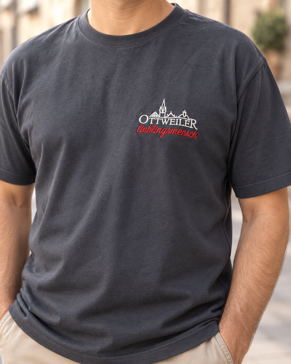 Mann trägt das dunkelgraue Ottweiler Lieblingsmensch T-Shirt mit weißer Ottweiler-Silhouette und rotem Schriftzug „lieblingsmensch“ auf der linken Brust